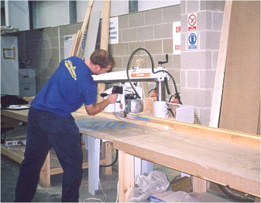 A length of timber is cut on the Maggi Junior 640 radial arm saw at Selco.